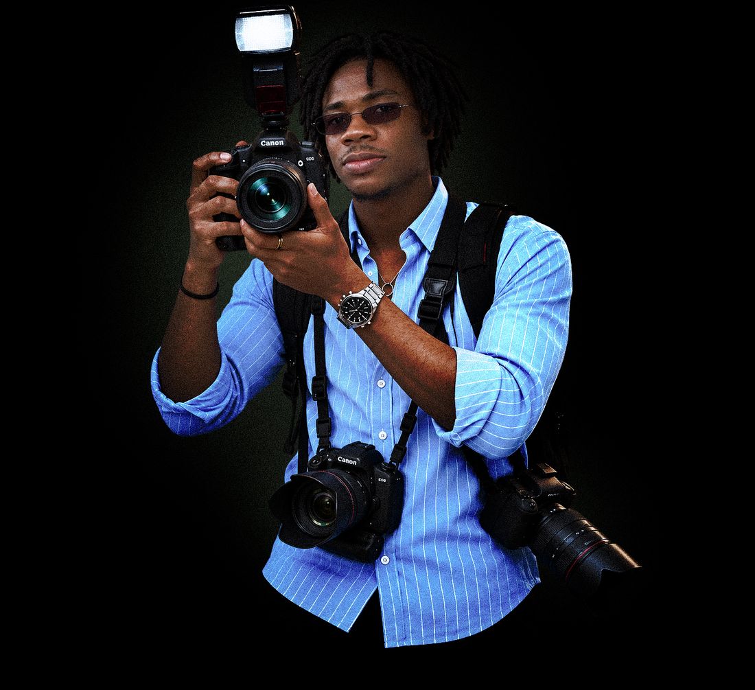 Éric Rocher, appareil photo Canon en main, sur fond noir