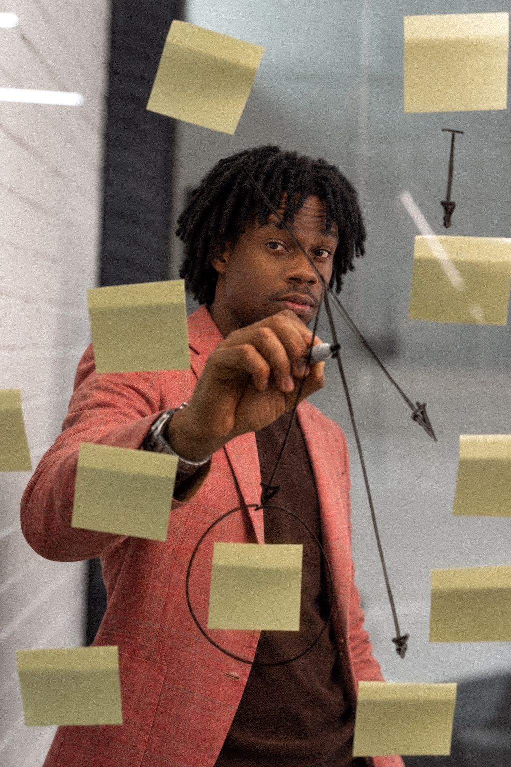 Éric Rocher dessinant un schéma stratégique sur une vitre couverte de post-it